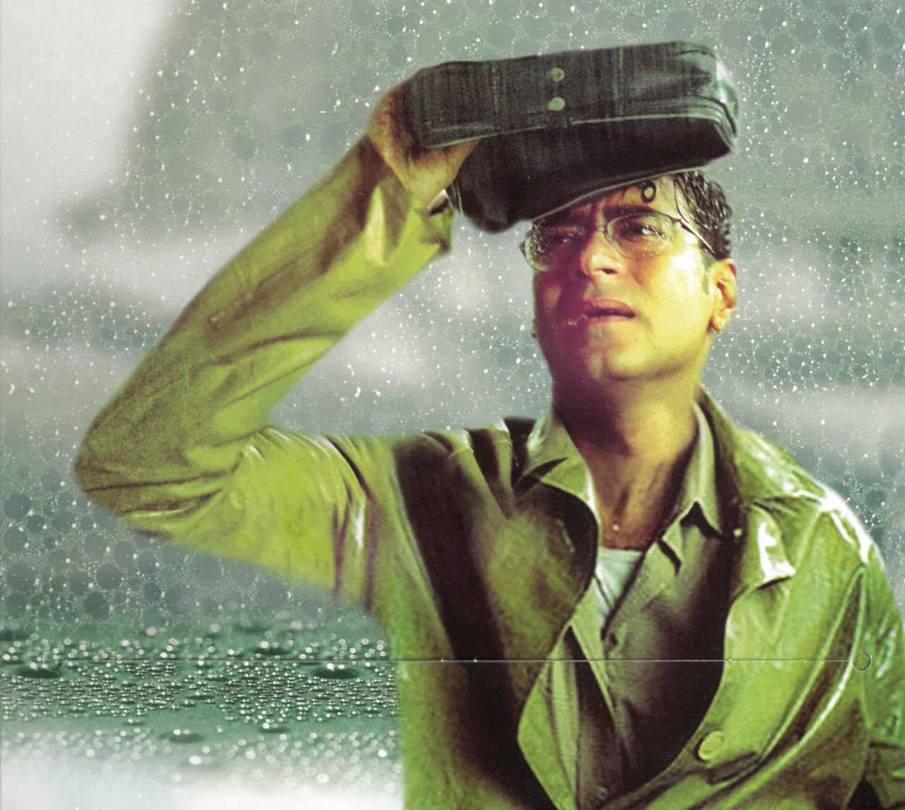 Ajay Devgn holding his bag over his head in the rain